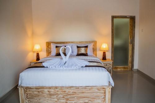 a bedroom with a large bed with a large mirror at Kayu Kuning Cottage in Nusa Penida