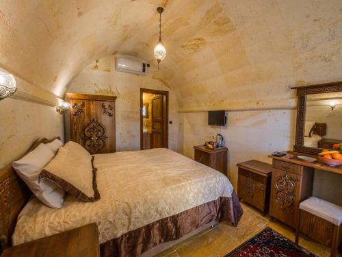 a bedroom with a large bed and a mirror at Lucky Cave Hotel Cappadocia in Goreme
