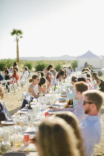 a group of people sitting at a long table at The Castle House Estate in Joshua Tree