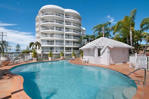 una piscina frente a un gran edificio de apartamentos en The Atrium Resort en Gold Coast