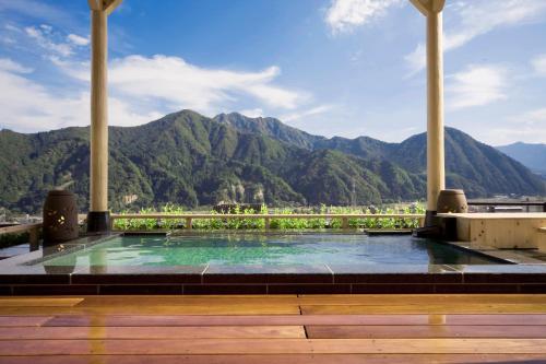 a swimming pool with mountains in the background at Hotel Futaba in Yuzawa