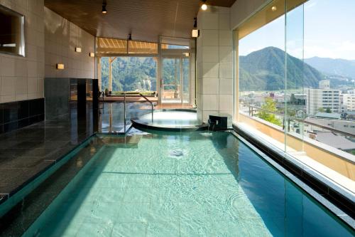 a large swimming pool in a building with a large window at Hotel Futaba in Yuzawa