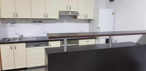 a kitchen with white cabinets and a black counter top at Sobe EMILIJA in Veliko Gradište