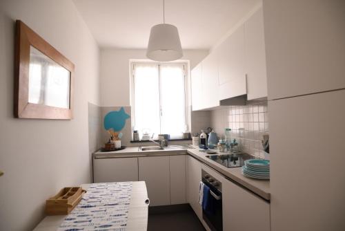 a kitchen with white cabinets and a sink and a window at 1919 in Sestri Levante