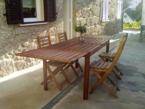 a wooden table and chairs sitting next to a building at Casa do Chico in Vieira do Minho