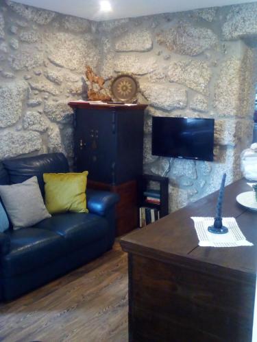 a living room with a couch and a stone wall at Casa do Chico in Vieira do Minho
