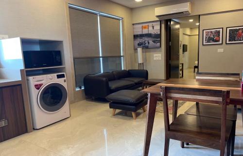 a living room with a washing machine and a couch at Theory9 Premium Service Apartments Khar in Mumbai