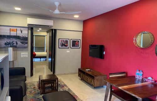 a living room with a red wall at Theory9 Premium Service Apartments Khar in Mumbai