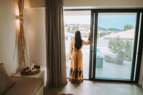 a woman looking out the window of a house at Crystal Waters in Nikiana