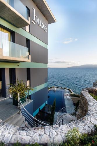 a building with a swimming pool next to the ocean at Buzë Boutique Hotel in Sarandë