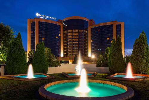 uma fonte em frente a um hotel à noite em InterContinental Almaty, an IHG Hotel em Almaty