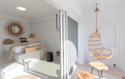a white room with a bed and a mirror at Iphimedeia Luxury Hotel & Suites in Naxos Chora