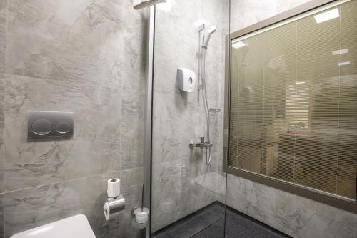 a bathroom with a glass shower with a toilet at Best Western Premier Karsiyaka Convention & Spa Hotel in Izmir