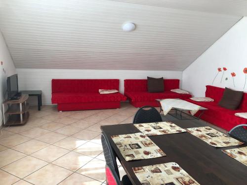 un soggiorno con divani rossi e tavolo di Apartment BLN a Oststeinbek