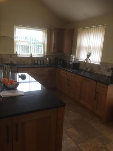 a kitchen with wooden cabinets and black counter tops at Private room Bishop Norton in Market Rasen