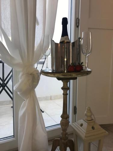 uma mesa com dois copos e uma garrafa de vinho em Ammos Luxury Studios em Aliki