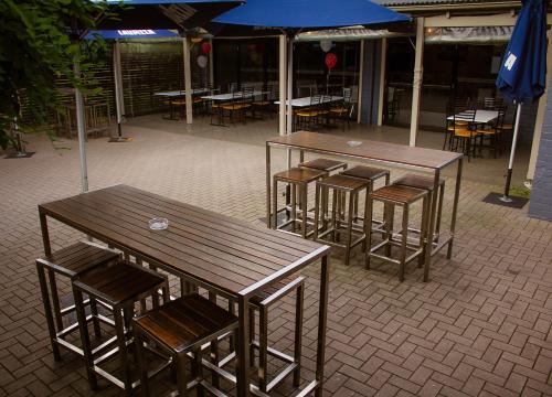a group of tables and chairs with umbrellas at Sunnyside Tavern in Newcastle