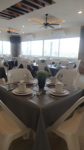 a dining room with a table and white chairs at Hotel Tampico Express in Ciudad Madero