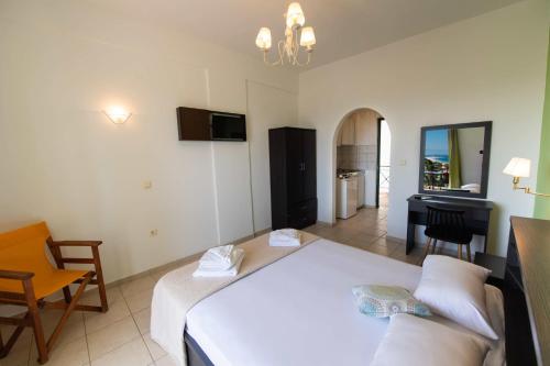 a bedroom with a large white bed and a desk at Bella Casa Studios by Imagine Lefkada in Lefkada Town