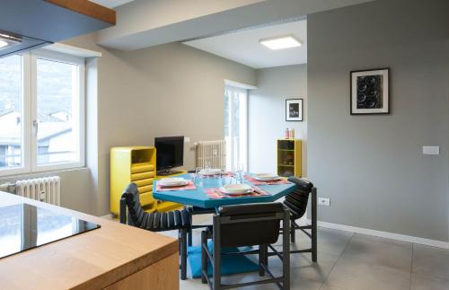 a dining room with a blue table and chairs at Appartamento Stelvio in Morbegno