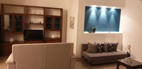 sala de estar con sofá y TV en Le Mie Stelle, en La Spezia
