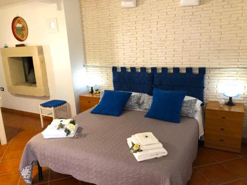 トッレ・パリにあるCasa Quintinaのベッドルーム1室(青い枕とタオル付きのベッド1台付)