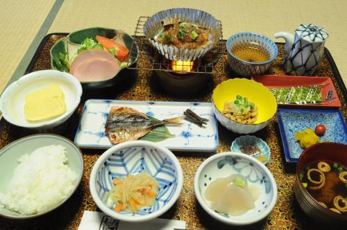a table topped with bowls and plates of food at Izumi-so in Gero