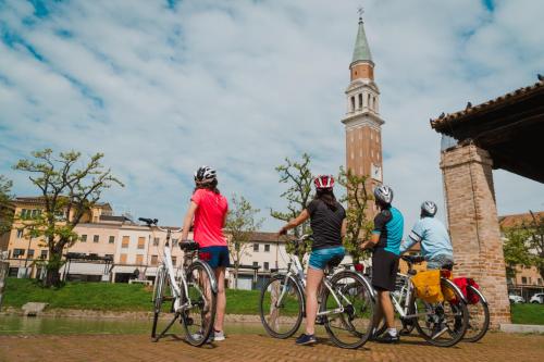 a group of people riding bikes in front of a tower at Hotel Casa a Colori Venezia in Dolo
