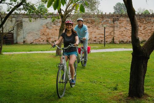 a man and a woman riding bikes in a park at Hotel Casa a Colori Venezia in Dolo