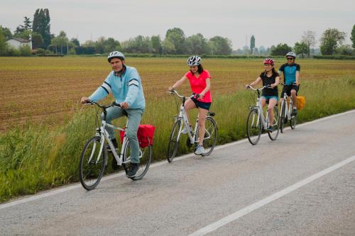 a group of people riding bikes down a road at Hotel Casa a Colori Venezia in Dolo