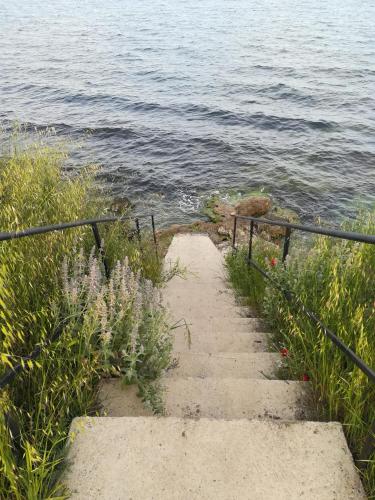 a set of stairs leading to the water with flowers at Hotel Diva in Ravda