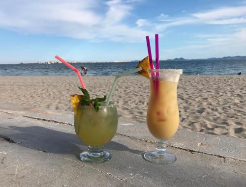 two drinks sitting on a table at the beach at Sheron's Apartment in Los Alcázares