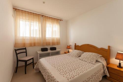 - une chambre avec un lit, une chaise et une fenêtre dans l'établissement Lets Holidays apartment Can Telm, à Tossa de Mar