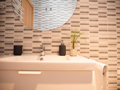 łazienka z umywalką i lustrem w obiekcie Stylish Apartment in the heart of Málaga with Pool w Maladze