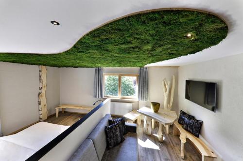 a room with a couch and a table and a tv at Hotel Ratschingserhof in Racines