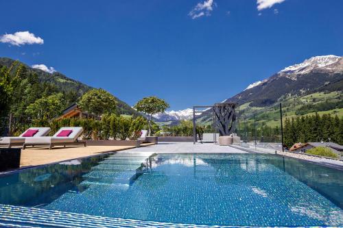 a swimming pool with mountains in the background at Hotel Ratschingserhof in Racines