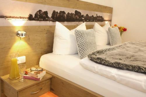 a bedroom with a bed with white pillows at Haus Chiemsee-Blick in Gstadt am Chiemsee