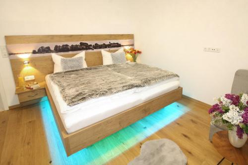 a bedroom with a large bed with a wooden headboard at Haus Chiemsee-Blick in Gstadt am Chiemsee