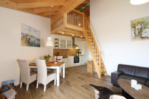 a living room and kitchen with a table and a staircase at Haus Chiemsee-Blick in Gstadt am Chiemsee