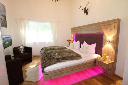 a bedroom with a large bed with pink lighting at Haus Chiemsee-Blick in Gstadt am Chiemsee