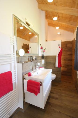 a bathroom with a white sink and a mirror at Haus Chiemsee-Blick in Gstadt am Chiemsee