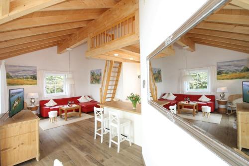 a loft conversion with red furniture and wooden ceilings at Haus Chiemsee-Blick in Gstadt am Chiemsee