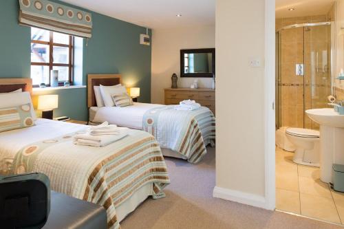 a hotel room with two beds and a bathroom at Tryfan Cottage in Betws-y-coed