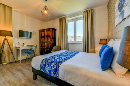Habitación de hotel con cama y escritorio en Logis Hostellerie du Neez, en Gan