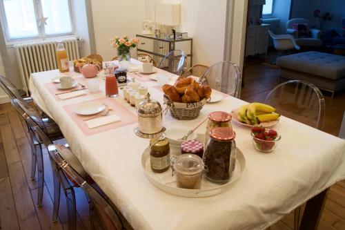 une table avec un tissu de table blanc et de la nourriture dans l'établissement La maison de Montaboulin, à Châteauroux