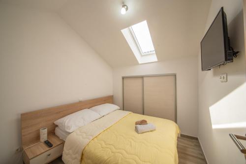 a small bedroom with a bed and a television at Apartman Eva in Vrsi