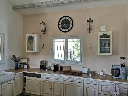 a kitchen with a large clock on the wall at La casa in Ongles