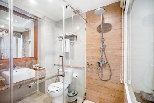 a bathroom with a shower and a toilet and a sink at 247 Boutique Hotel in Pattaya Central