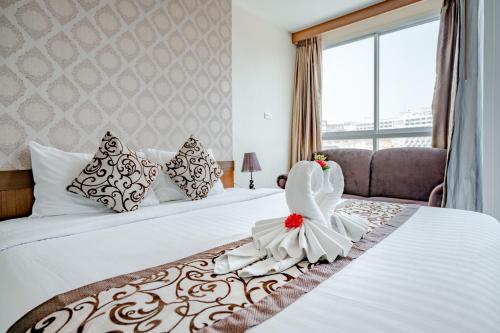 a hotel room with two beds with a bride sitting on it at 247 Boutique Hotel in Pattaya Central