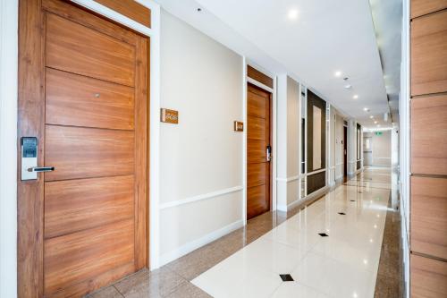 a hallway with wooden doors and white walls at 247 Boutique Hotel in Pattaya Central